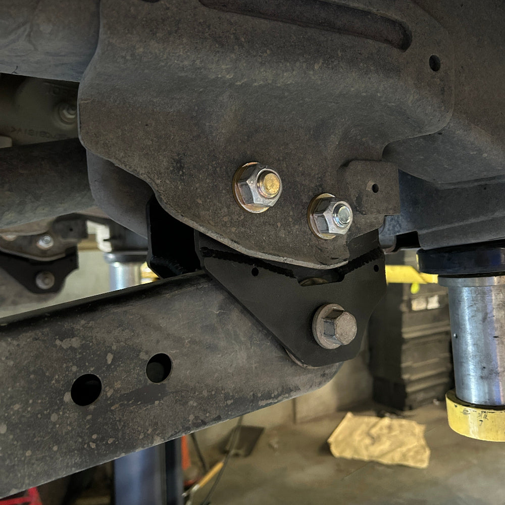 Close-up of a vehicle suspension system with bolts and metal components.