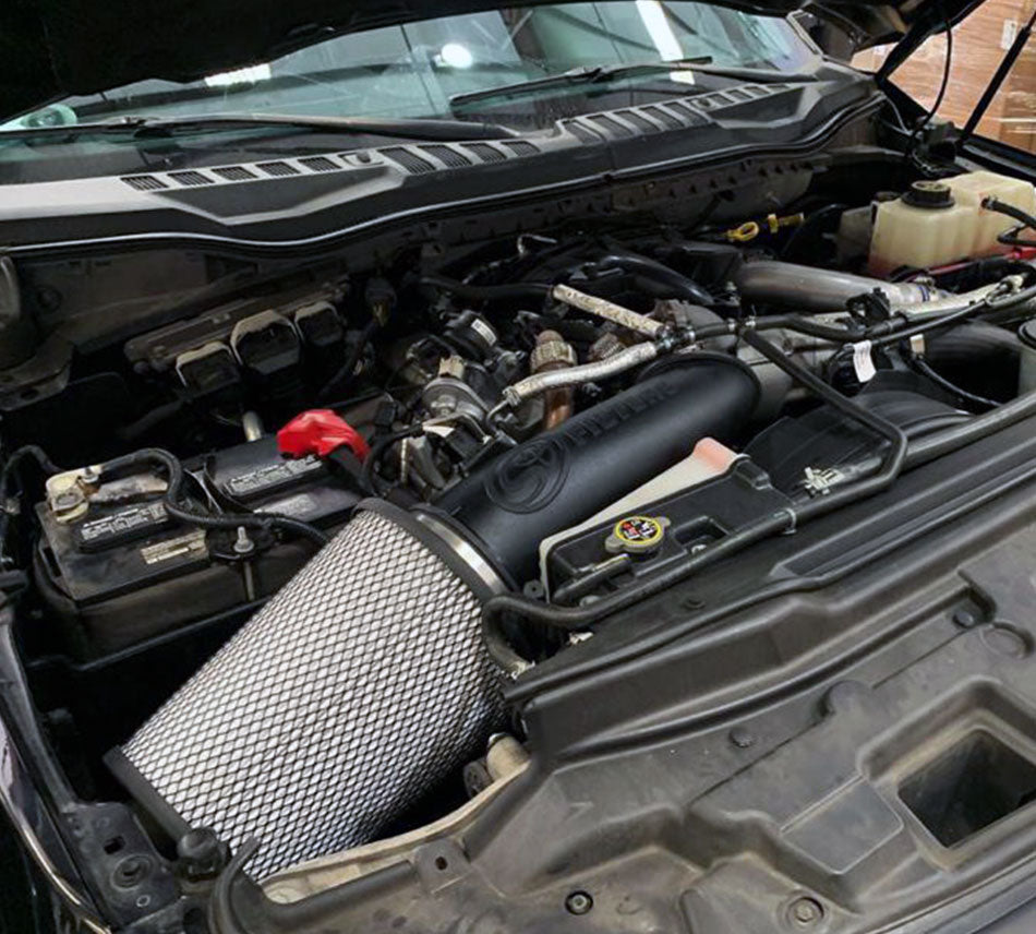 Dry Extendable Open Air Intake for 2017-2019 Ford Super Duty, 6.7L Powerstroke installed in the engine compartment of a vehicle.

