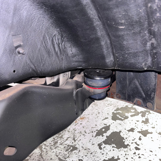 Close-up of a car's undercarriage with a Body Mount Kit For 1980-1996 Ford Bronco attached.