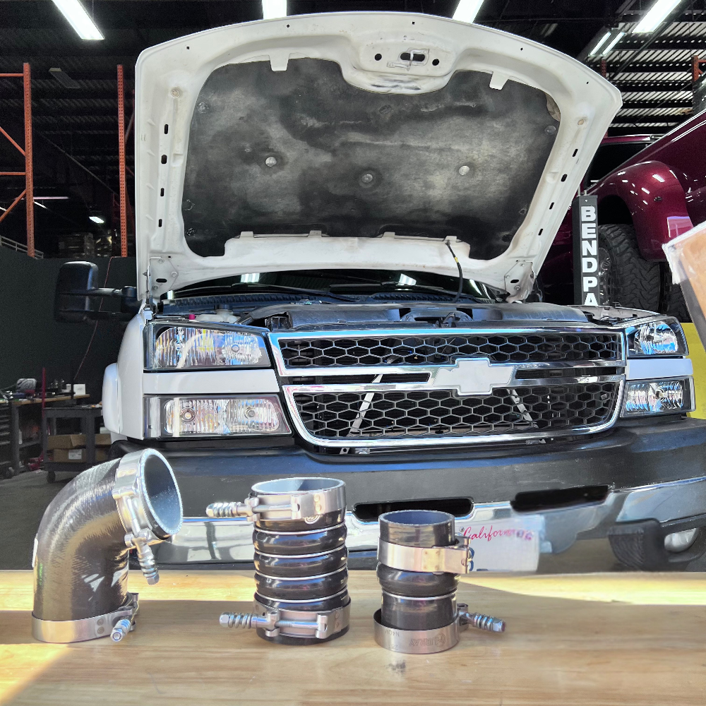 Car with open hood and an Hot and Cold Side Boot Kit For 2006-2010 Chevy / GMC Duramax 6.6L (LBZ & LMM)on a table in a garage setting