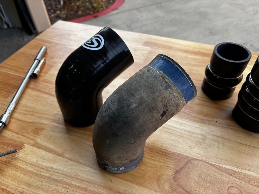 Car with open hood and an Hot and Cold Side Boot Kit For 2006-2010 Chevy / GMC Duramax 6.6L (LBZ & LMM)on a table in a garage setting
