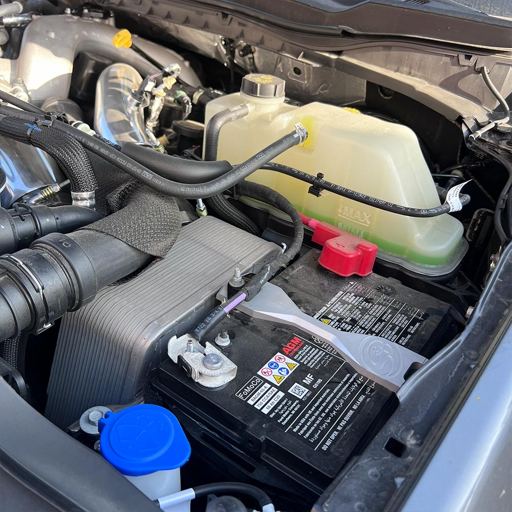 SB Filters Car billet battery hold down brackets and engine compartment with visible labels and branding.