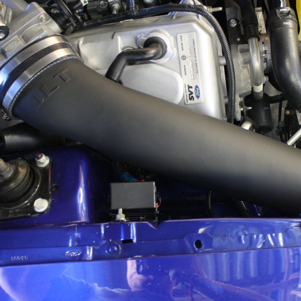 A JLT 12" High Boost Cold Air Intake for 2003-2004 SVT Cobra installed in the engine compartment of a red vehicle.
