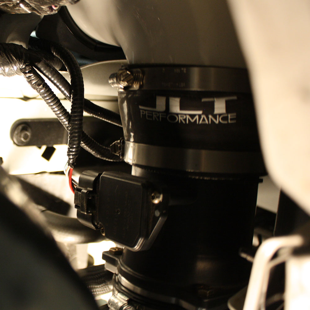 Close up of a A JLT 12" High Boost Cold Air Intake for 2003-2004 SVT Cobra installed in the engine compartment of a  vehicle.