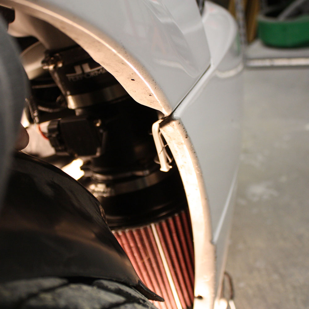 Close up of a A JLT 12" High Boost Cold Air Intake for 2003-2004 SVT Cobra installed in the engine compartment of a vehicle.