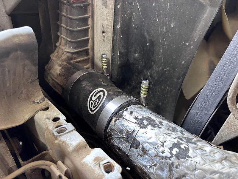 Close-up of an SB Filters Hot and Cold Side Boot Kit for 1999.5-2003 Ford F250/F350, 7.3L Powerstroke installed in a car