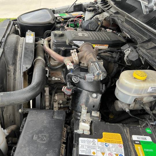 
  Open car hood revealing an SB Filters  Intake Elbow For 2007.5-2018 Dodge Ram 2500, 3500 6.7L Cummin and battery components.
