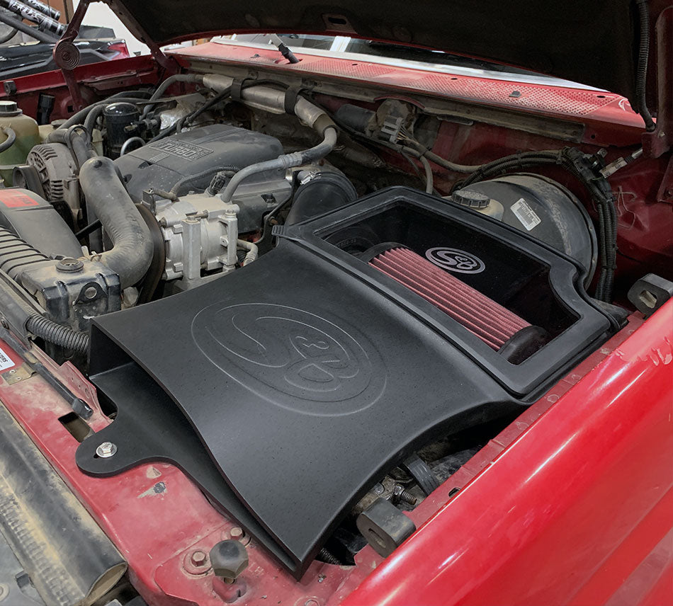 Cold Air Intake for 1994-1997 Ford Powerstroke 7.3L on a white background installed in the engine compartment of a vehicle.
