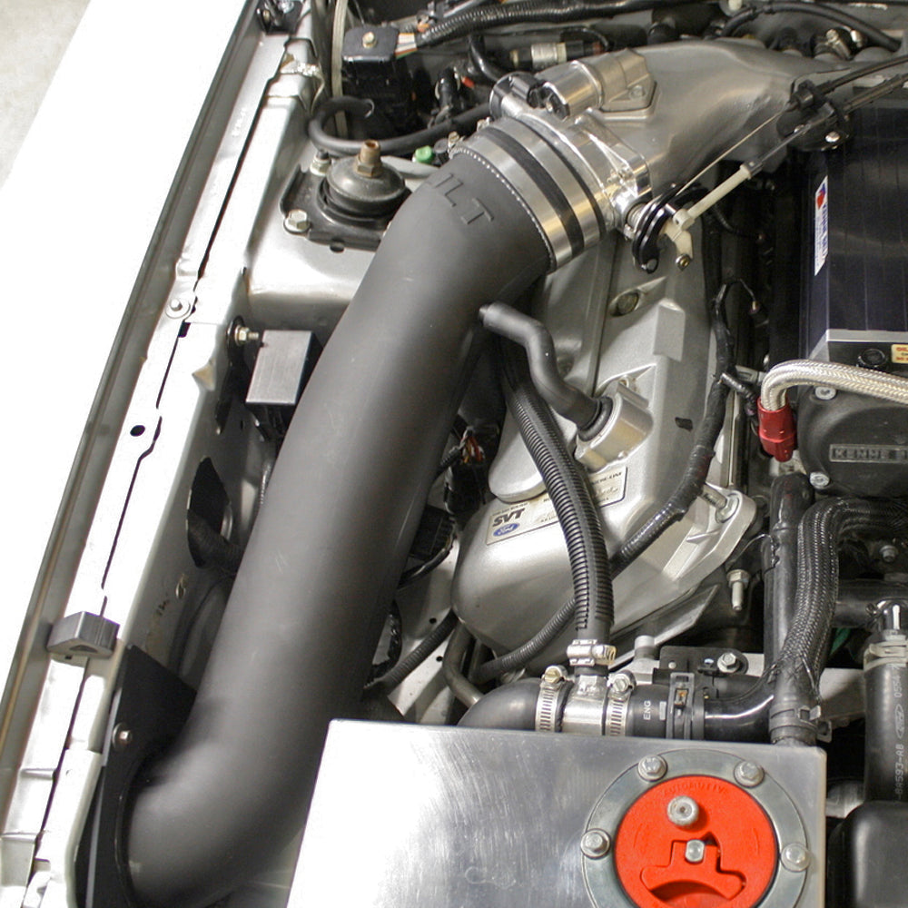 A JLT 12" High Boost Cold Air Intake for 2003-2004 SVT Cobra installed in the engine compartment of a red vehicle.